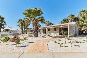 a house on the beach with palm trees at RAC Monkey Mia Dolphin Resort in Monkey Mia
