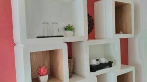 a white shelf in a room with some plants at Hinnam Saisuay by One in Hua Hin