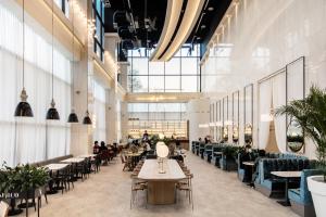 a restaurant with tables and chairs and people sitting at tables at WesternLife Hotel in Iksan