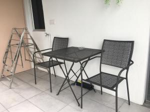 a table and two chairs and a ladder at Signel Hostel in Kota Kinabalu