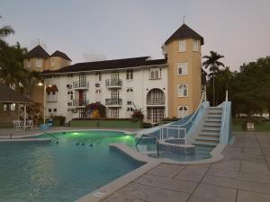 a swimming pool with a slide in front of a building at Apartment Treasure at Sandcastles in Ocho Rios