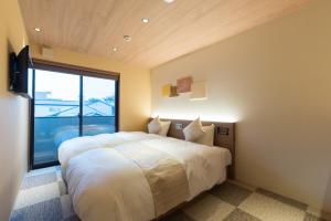 um quarto com uma cama grande e uma janela grande em Stay SAKURA Kyoto Higashi Hongan-ji I em Quioto