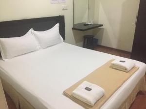 a bed with two towels sitting on top of it at Hotel Sri Malim Sungkai in Sungkai