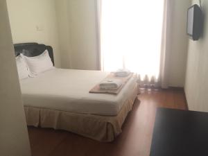 a bed in a room with a large window at Hotel Sri Malim Sungkai in Sungkai