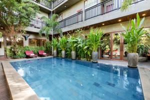 a swimming pool in front of a building with plants at Won Residence & Spa in Siem Reap