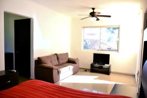 a living room with a couch and a ceiling fan at Departamentos Luminar in Mazatlán