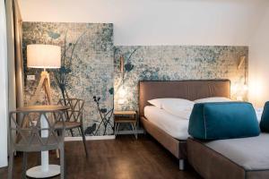 una camera con letto, tavolo e sedia di Stay COOPER l Guesthouse zum Löwen a Merano