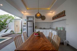 a kitchen and dining room with a wooden table and chairs at Villa Arif in Seminyak