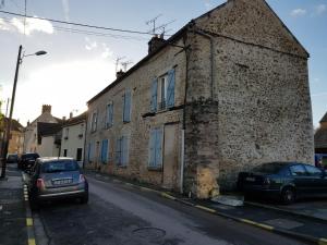 ein altes Backsteingebäude an der Straßenseite in der Unterkunft Mas des sources in Boissy-sous-Saint-Yon