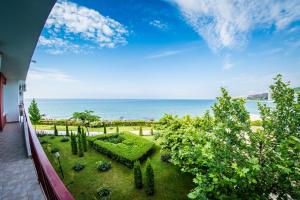 a balcony with a view of a garden and the ocean at Privilege Fort Beach Apartments in Sveti Vlas