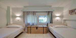 a bedroom with two beds and a window at Ekatis Houses in Sani in Sani Beach