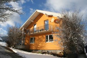 a house with a balcony in the snow at Ferienhaus Grohs in Neumarkt in Steiermark