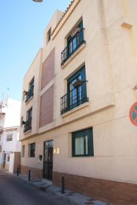 un edificio con ventanas y balcones en una calle en Apartamentos Flores, en Torremolinos