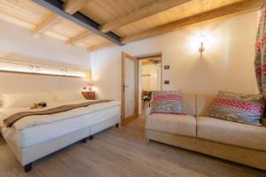 een slaapkamer met een bed en een bank bij Maison Julie-lungo la via Francigena in Etroubles