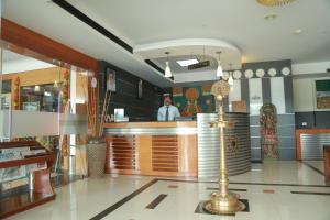 a man standing at a bar in a restaurant at Hotel Jyothis Regency in Palakkad