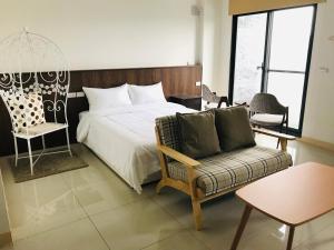 una camera da letto con un letto, una sedia e un divano di Moo House a Dayin