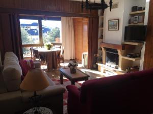 sala de estar con chimenea y mesa de comedor en Apartment Plaza de Pradollano, en Sierra Nevada