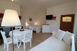 a living room with a white couch and a table at Villa SORENTO in Mielno