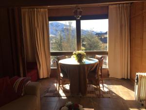 una mesa en una habitación con una ventana grande en Apartment Plaza de Pradollano, en Sierra Nevada