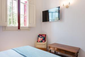 a bedroom with a bed and a tv and a chair at Hotel Torre Barcelona in Sant Cugat del Vallès