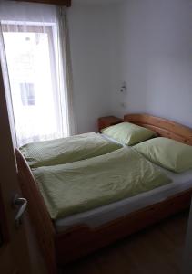 Bett in einem Schlafzimmer mit Fenster in der Unterkunft Temblhof in Sterzing