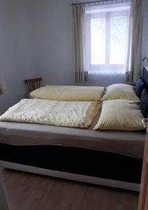 ein Bett mit zwei Kissen und ein Fenster in einem Zimmer in der Unterkunft Temblhof in Sterzing