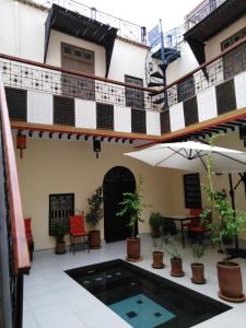 a courtyard of a building with a pool and plants at Riad JEREMY in Marrakesh