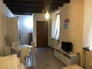 un soggiorno con tavolo e TV e una camera con divano di MyRoom Center Flat a Bergamo