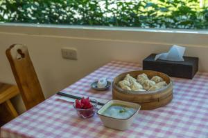 a table with a bowl of food and a bowl of bread at Yuan Qiwu Homestay in Pinghe