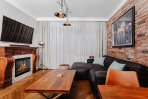 - un salon avec un canapé et une cheminée dans l'établissement Apartament Indygo, à Łomża