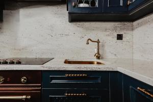 a kitchen with blue cabinets and a sink at Apartament Indygo in Łomża