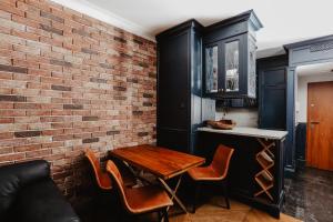 a dining room with a table and a brick wall at Apartament Indygo in Łomża