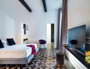 Habitación de hotel con cama y TV en Habitat, en Catania