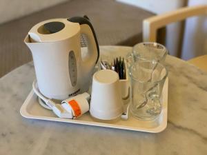 佛罗伦萨佛罗伦萨食宿酒店的茶壶和茶杯放在桌子上的托盘上 更多28张照片