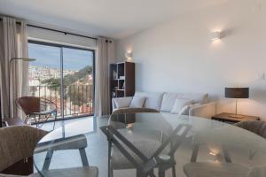 リスボンにあるModern Apartment with View near Castelo de São Jorgeのリビングルーム(ガラスのテーブル、椅子付)