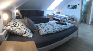 a bedroom with a bed with pillows and a couch at Sobe-Rooms Kvatric in Zagreb