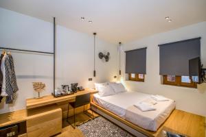 a bedroom with a bed and a desk and windows at Portou House in Chania Town