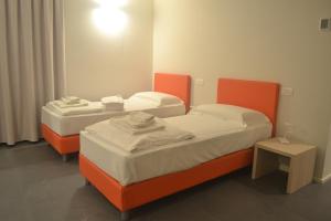 twee bedden met oranje frames in een kamer bij StraVagante Hostel & Rooms in Verona