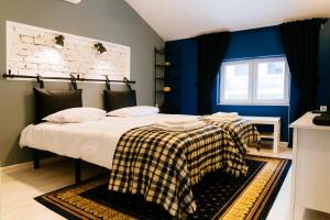 a bedroom with a bed with a checkered blanket on it at Beautiful best location apartment "Blue Mouse" in Plovdiv