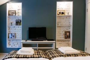 a room with a tv and a desk with a bed at Beautiful best location apartment "Blue Mouse" in Plovdiv