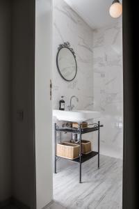 a white bathroom with a sink and a mirror at Beautiful best location apartment "Blue Mouse" in Plovdiv