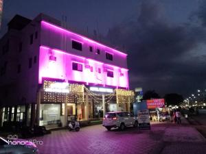 a building with purple lights on the side of it at Hotel Neem Tree in Shirdi