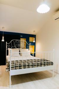 a white bed in a room with a blue wall at Beautiful best location apartment "Blue Mouse" in Plovdiv