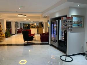 a lobby with a video game machine and chairs at Dean Hamlet Hotel in St. Julianʼs