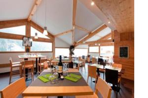 a dining room with wooden tables and chairs at Montagne Duplex-Orelle 9 pers. avec SPA in Orelle