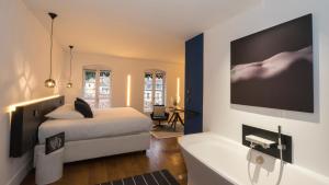 a bedroom with a bed and a tub and a tv at MiHotel Vieux Lyon in Lyon