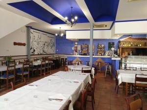 a dining room with white tables and chairs at Hostal Restaurante Ego's in Campo de Criptana