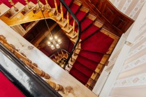 un escalier en colimaçon dans un bâtiment avec moquette rouge dans l'établissement Hotel & Restaurant "Deutscher Kaiser", à Perleberg