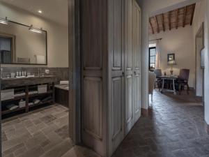 a kitchen with a refrigerator, a sink, and a dining room table at Castel Monastero - The Leading Hotels of the World in Castelnuovo Berardenga