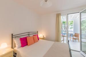 a bedroom with a bed with pink and orange pillows at Casa Bianca in Salento in Torre Santa Sabina